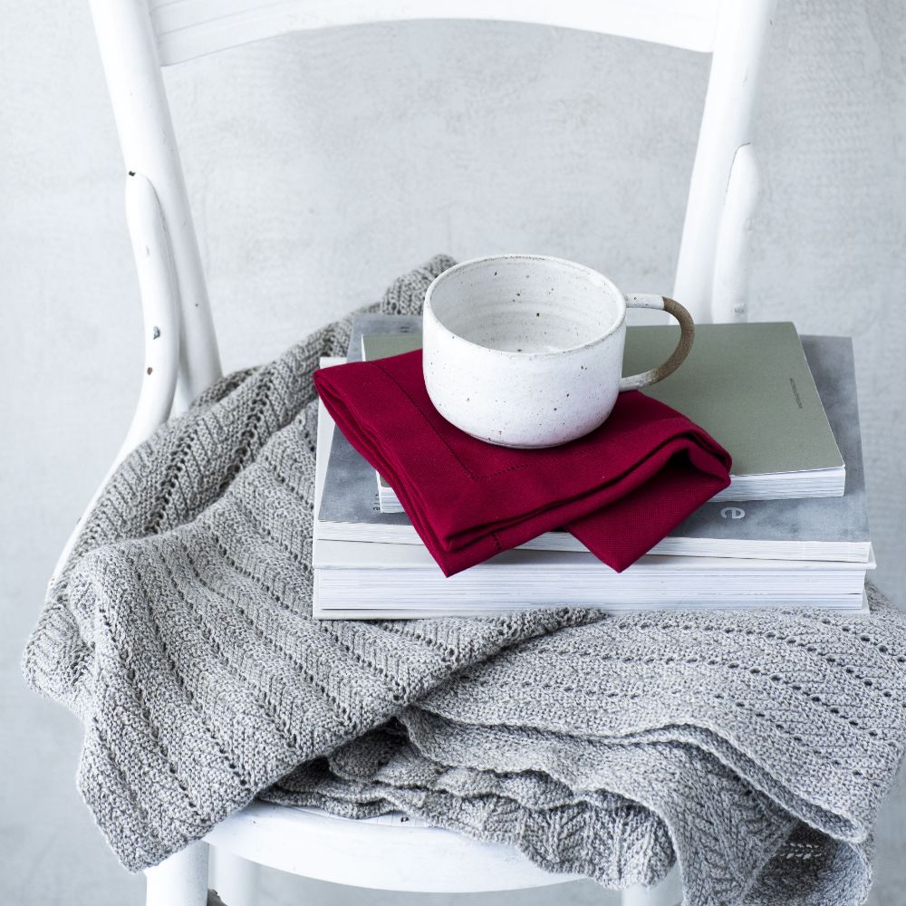 Mörkröd tygservett med broderad hålsöm