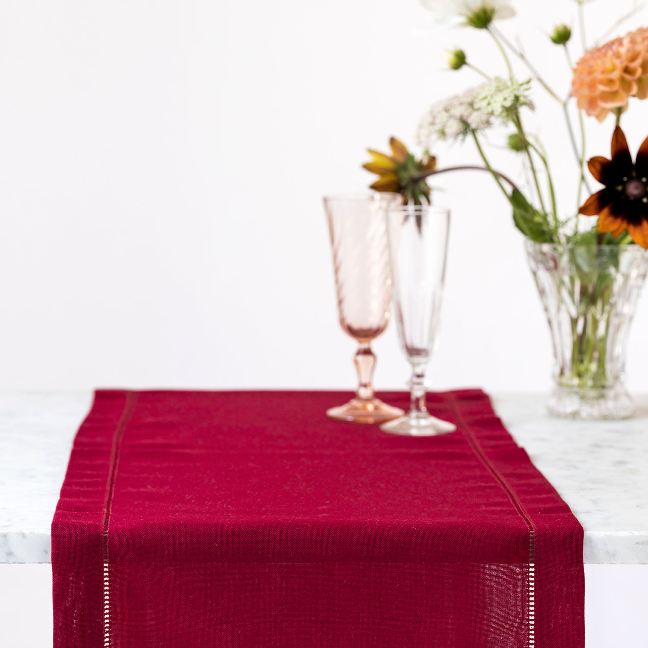 Mörkröd bordlöpare med broderad hålsöm